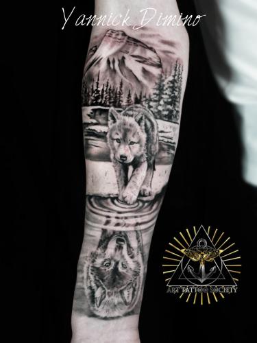 tatouage-loup-louveteau-foret-montagne-realiste